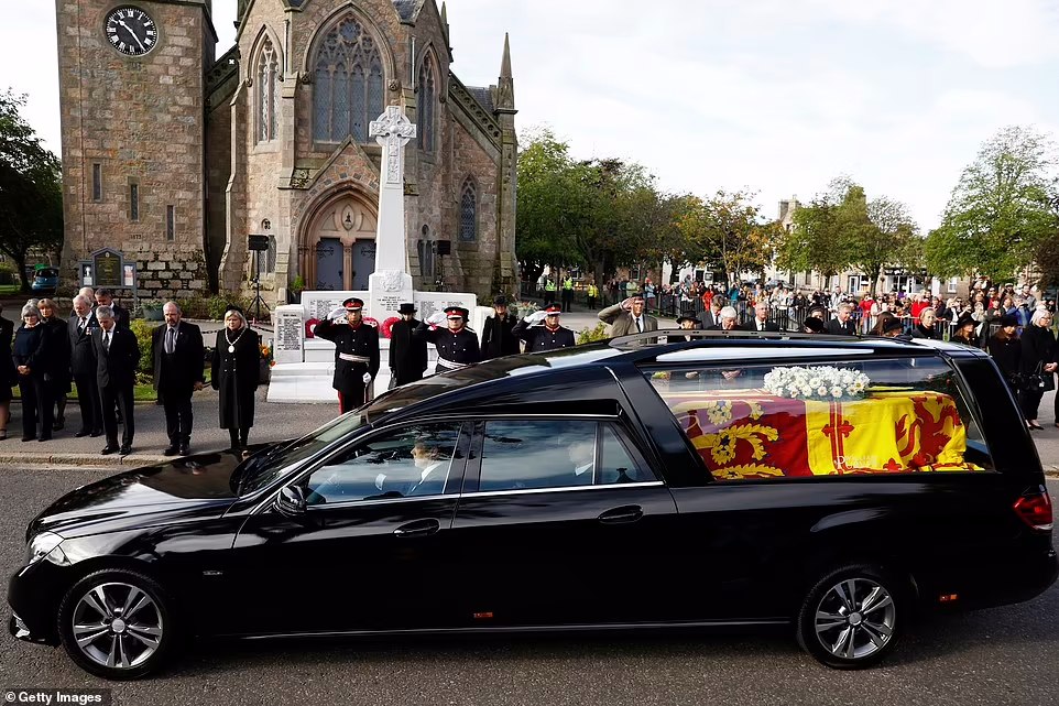 People in Ballater gather in tribute as the cortege carrying the coffin of the late Queen passes today